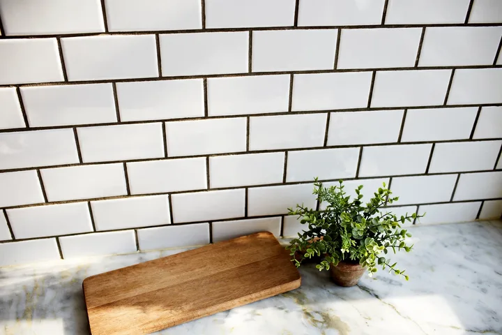 Close-up of white subway tile kitchen backsplash with dark grout
